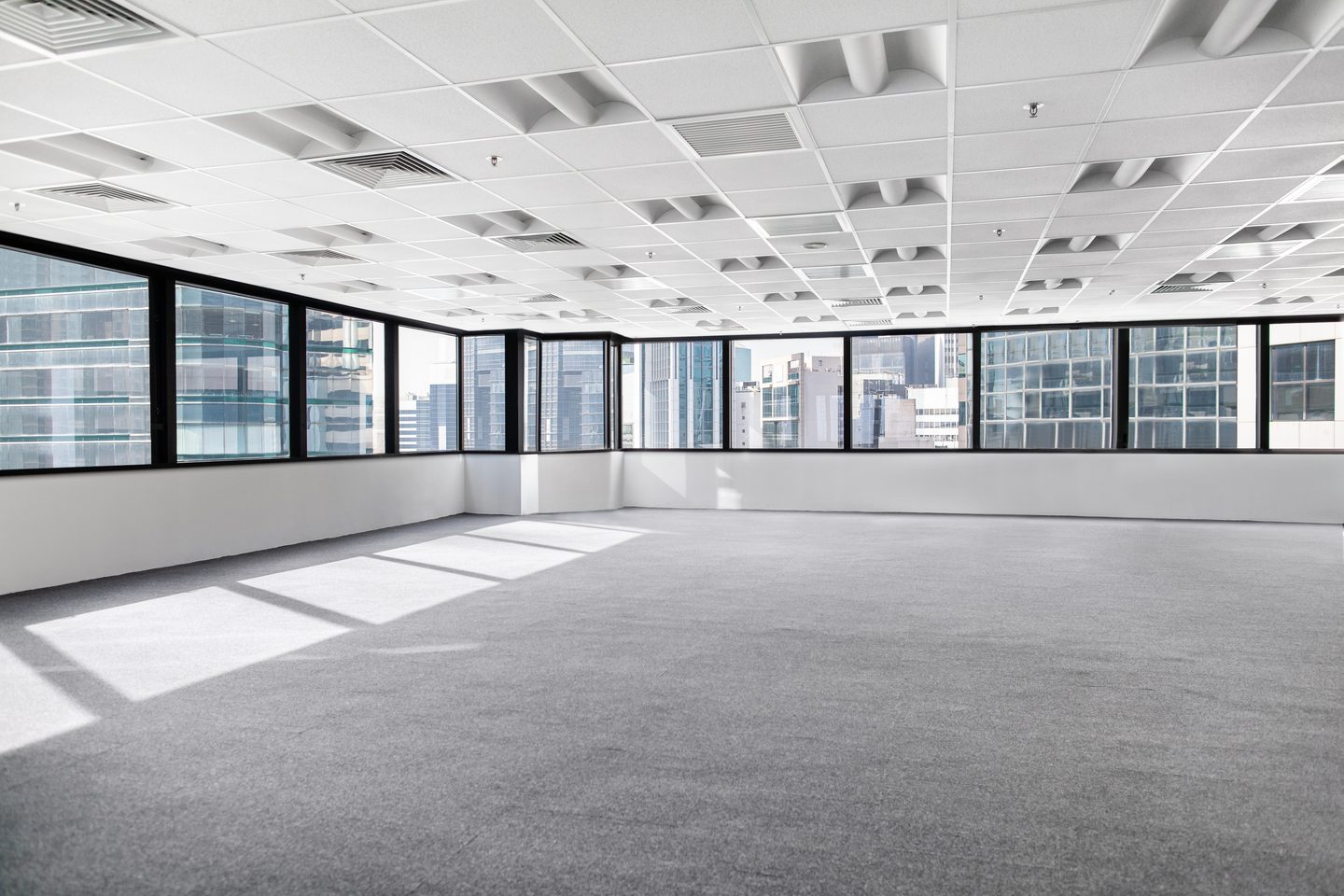 Empty open-plan office floor with full-height glazing